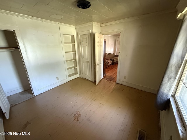 1207 Harrington St, Washington, NC 27889 - unfurnished bedroom with ornamental molding, a closet, and hardwood / wood-style floors