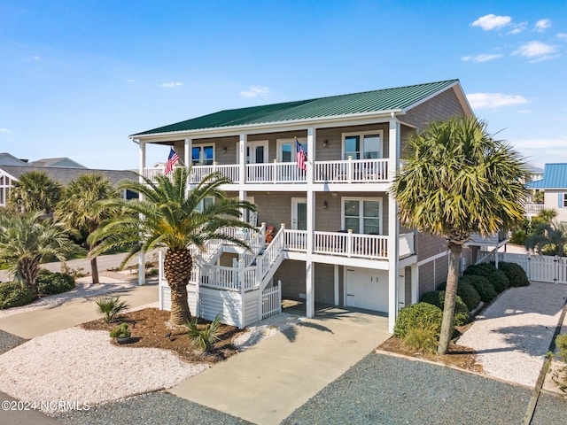 view of front of house with covered porch, a garage, and a balcony