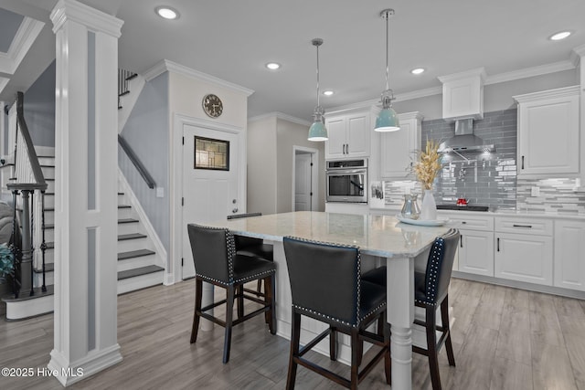 3953 Palm St SE, Bolivia, NC 28422 - kitchen with stainless steel oven, decorative backsplash, light wood-style flooring, wall chimney range hood, and recessed lighting