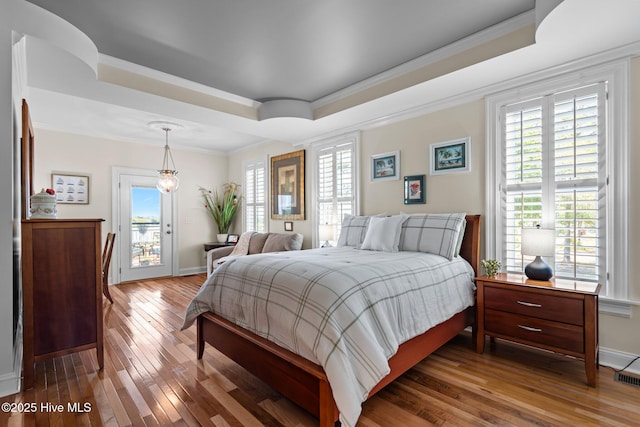 3953 Palm St SE, Bolivia, NC 28422 - bedroom featuring a raised ceiling, hardwood / wood-style flooring, access to exterior, ornamental molding, and baseboards