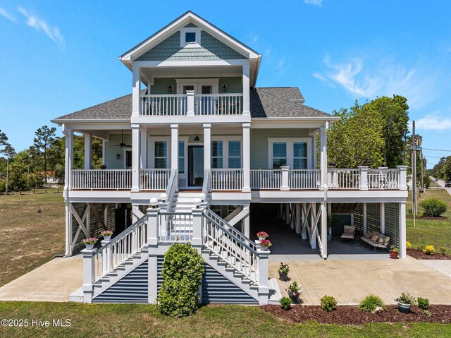 3953 Palm St SE, Bolivia, NC 28422 - raised beach house featuring a carport, covered porch, a ceiling fan, and roof with shingles