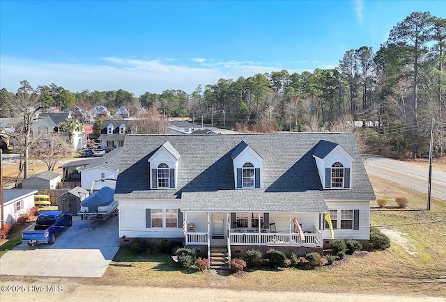 view of front of property with a porch, driveway, and a shingled roof