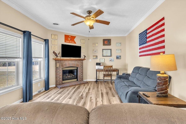 living room with ornamental molding, visible vents, a textured ceiling, and wood finished floors