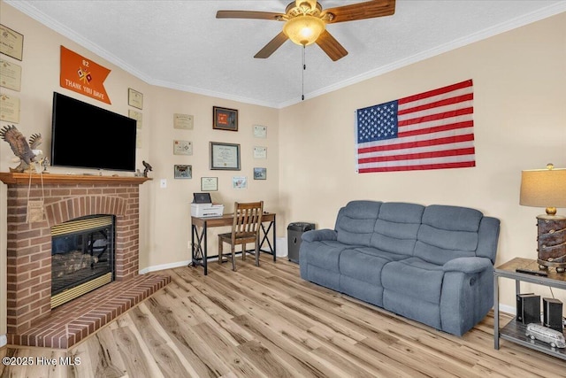 living area with a textured ceiling, a fireplace, ornamental molding, and wood finished floors