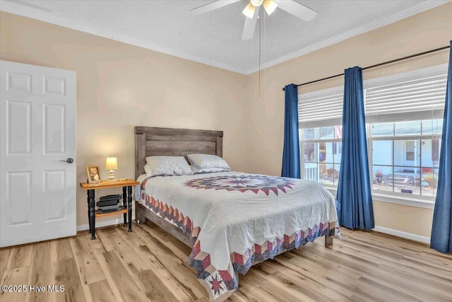 bedroom featuring baseboards, ornamental molding, ceiling fan, and wood finished floors