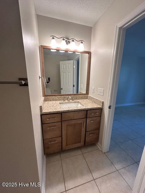 bathroom with vanity, tile patterned flooring, and a textured ceiling