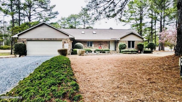 single story home featuring an attached garage, brick siding, and driveway