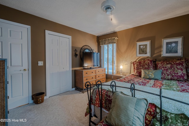 bedroom with a closet, carpet floors, and a textured ceiling