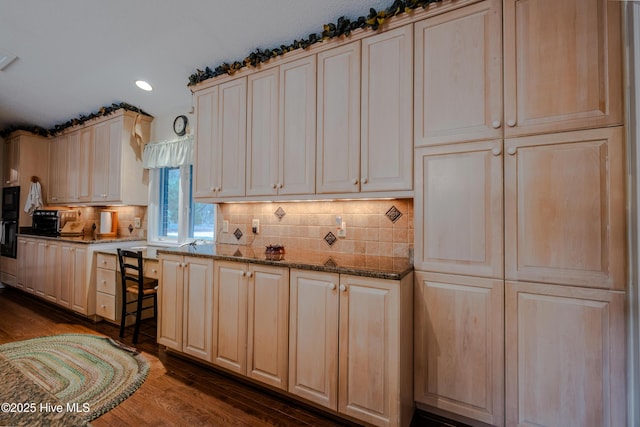 kitchen featuring light brown cabinetry, decorative backsplash, recessed lighting, dark stone countertops, and dark wood-style flooring