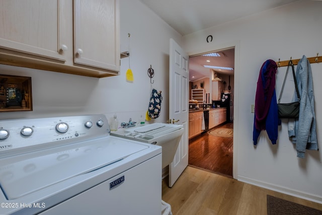 washroom featuring cabinet space, washer / clothes dryer, and light wood-type flooring