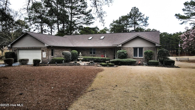 single story home featuring brick siding, a garage, and roof with shingles