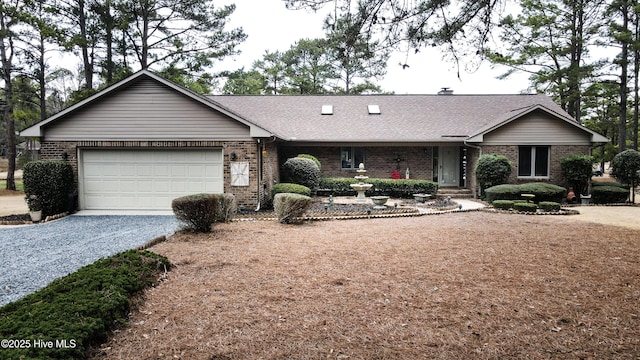 single story home featuring a garage, brick siding, gravel driveway, and a shingled roof