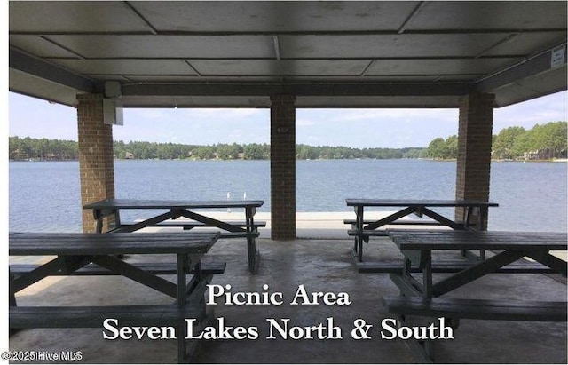 dock area with a patio and a water view