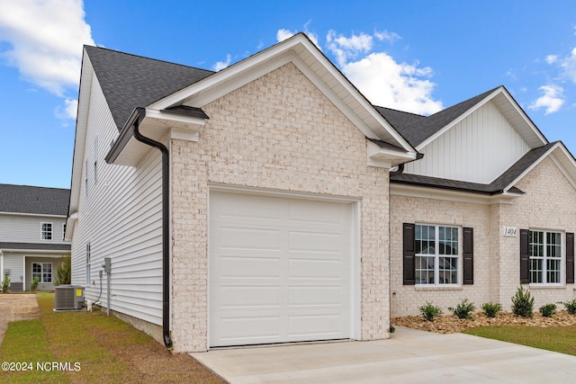 view of front of home with a garage, central AC, brick siding, driveway, and roof with shingles