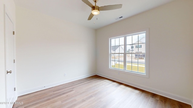 spare room featuring light wood-style flooring, visible vents, and baseboards