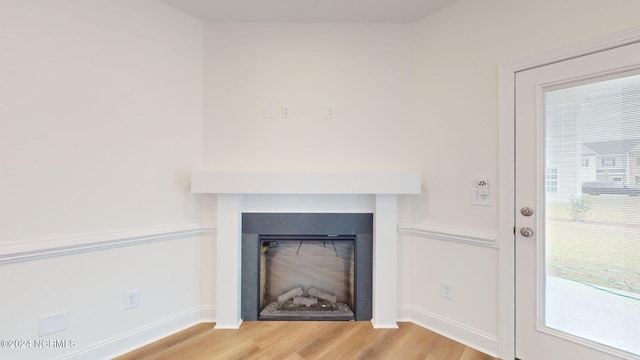 interior details with a fireplace, baseboards, and wood finished floors