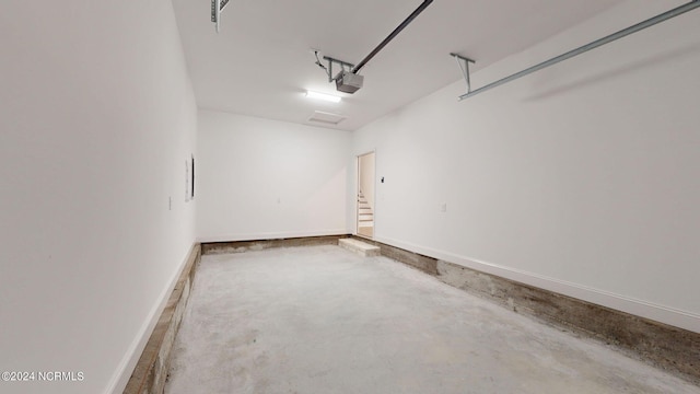 garage with baseboards and a garage door opener