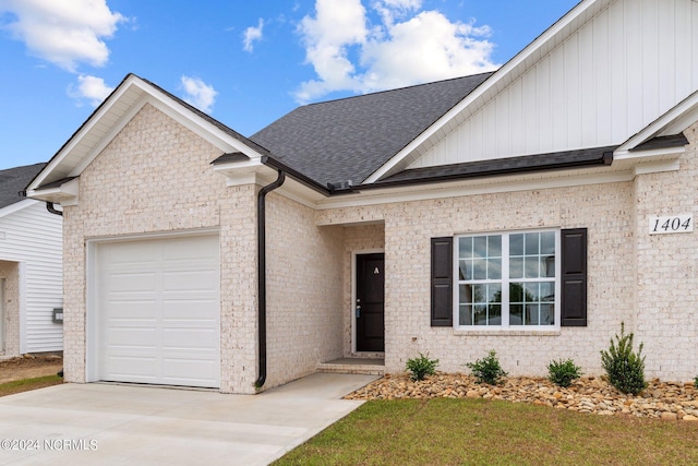 view of front of house with concrete driveway, a shingled roof, an attached garage, and brick siding