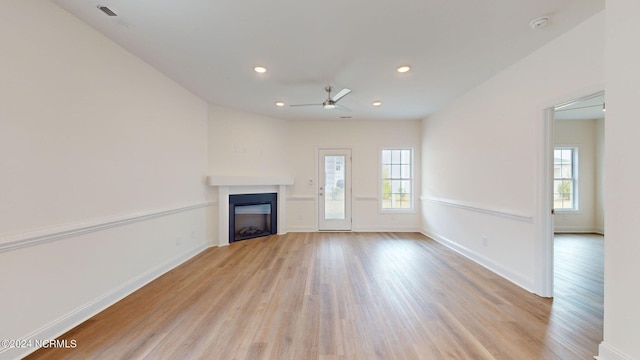 unfurnished living room with light wood-style floors, a fireplace, baseboards, and recessed lighting