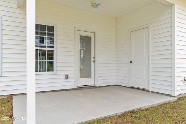 entrance to property with a patio area and a ceiling fan