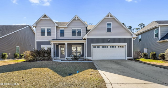 view of front of home featuring covered porch, a garage, and a front yard