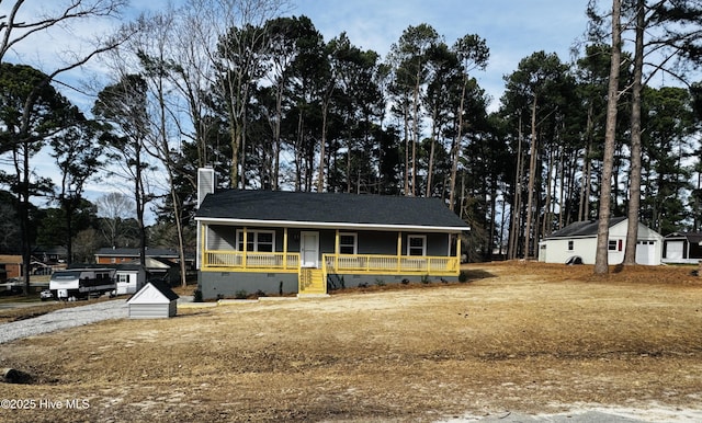 view of front facade featuring a porch, crawl space, and a chimney