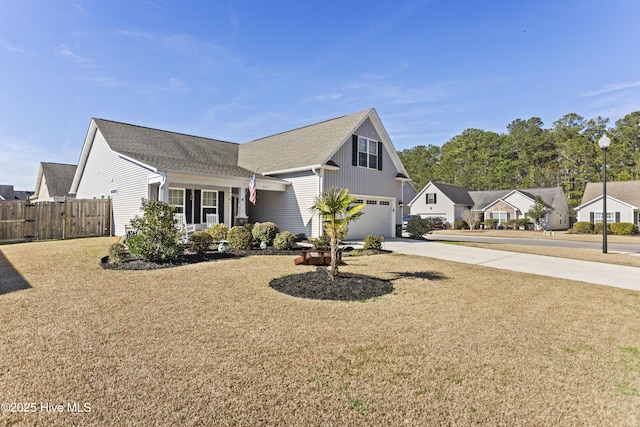 traditional home with a residential view, fence, driveway, and an attached garage