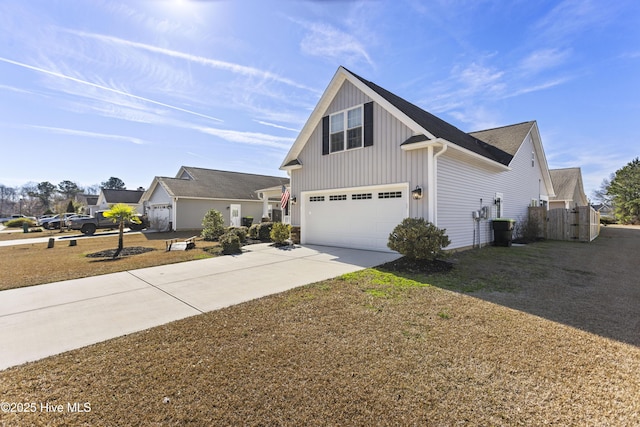 traditional home with a garage, concrete driveway, board and batten siding, and fence