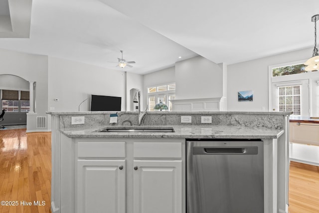 kitchen with open floor plan, white cabinetry, light wood-type flooring, and stainless steel dishwasher