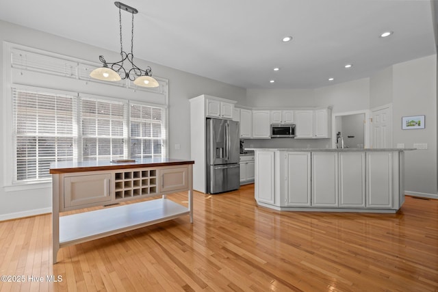 kitchen with recessed lighting, appliances with stainless steel finishes, light wood-style floors, white cabinets, and a sink