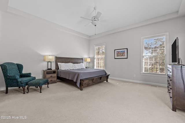 bedroom with baseboards, multiple windows, light colored carpet, and ceiling fan