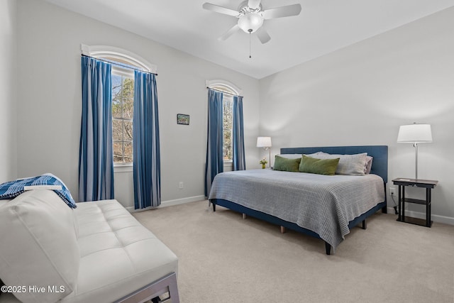 bedroom featuring baseboards, light colored carpet, and ceiling fan