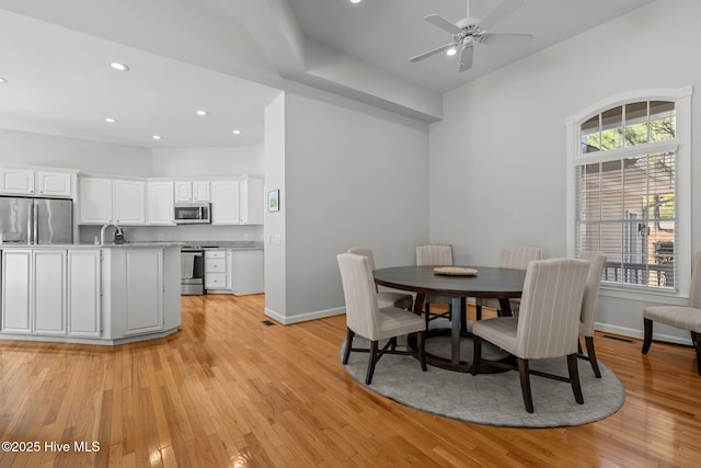 dining space with light wood-style flooring, recessed lighting, a ceiling fan, and baseboards