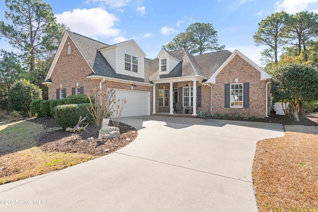 view of front of property with driveway, brick siding, a porch, and an attached garage