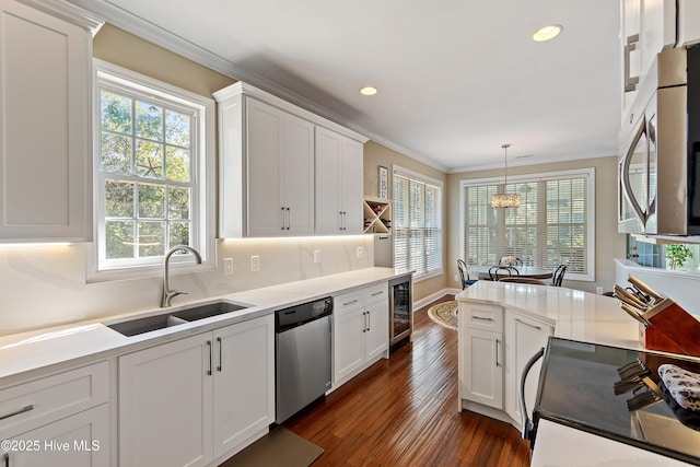 kitchen featuring a sink, wine cooler, crown molding, white cabinets, and appliances with stainless steel finishes