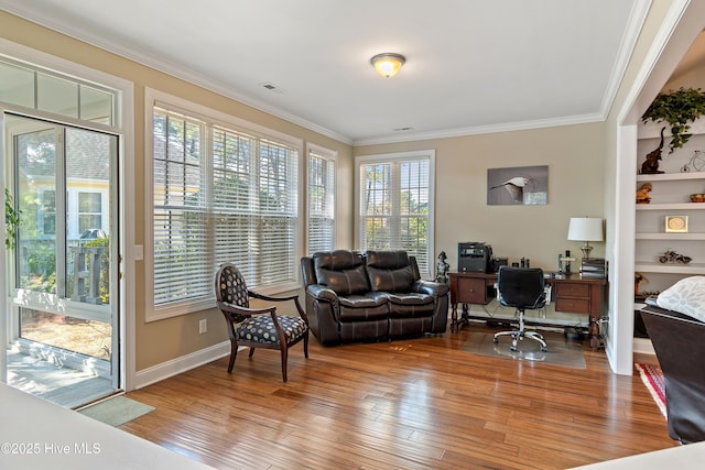 home office with hardwood / wood-style flooring, visible vents, and crown molding