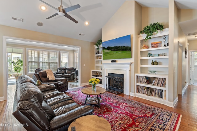 4155 Windham Ln, Southport, NC 28461 - living room featuring ceiling fan, plenty of natural light, a premium fireplace, wood finished floors, and high vaulted ceiling