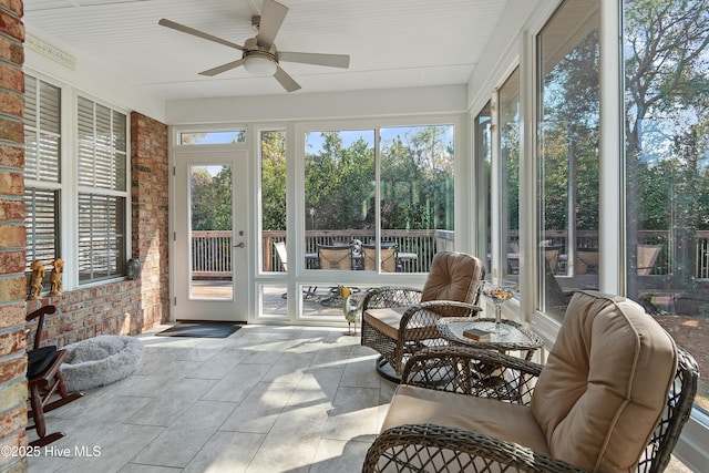 sunroom / solarium featuring a ceiling fan