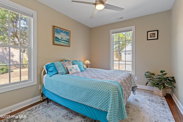 bedroom with baseboards, visible vents, wood finished floors, and ceiling fan