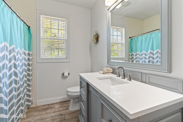 bathroom featuring a shower with shower curtain, toilet, wood tiled floor, vanity, and baseboards