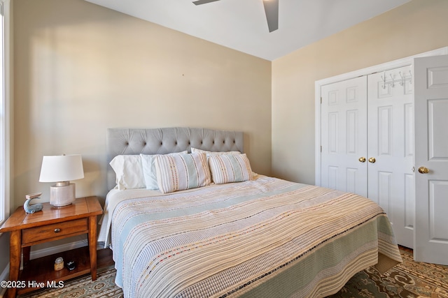 bedroom featuring wood finished floors, a ceiling fan, and a closet