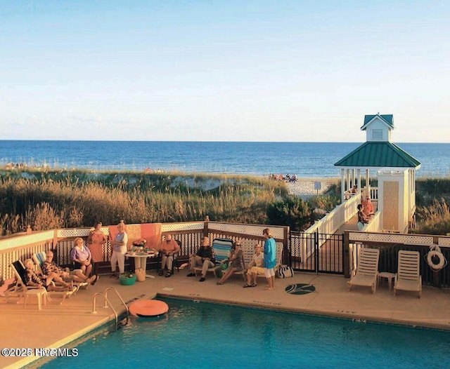 community pool with a water view and a gazebo