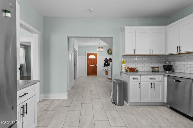 kitchen with white cabinetry, backsplash, stainless steel dishwasher, and light stone countertops