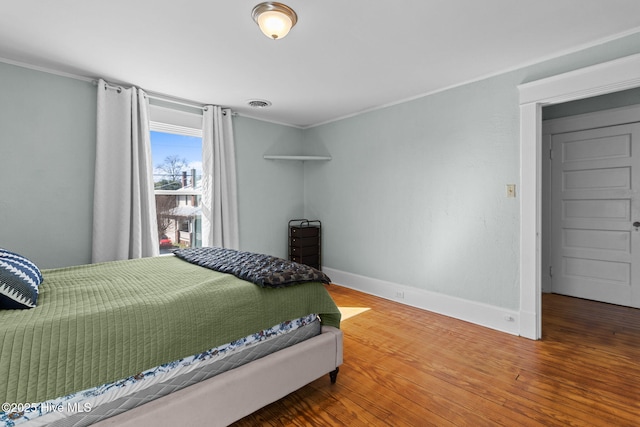 bedroom featuring crown molding and wood-type flooring