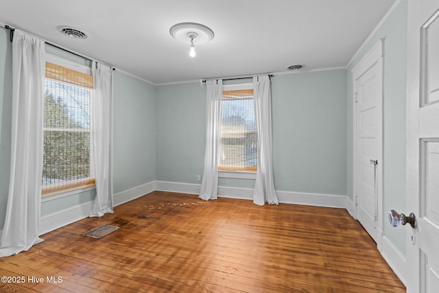 spare room featuring hardwood / wood-style floors, plenty of natural light, and ornamental molding