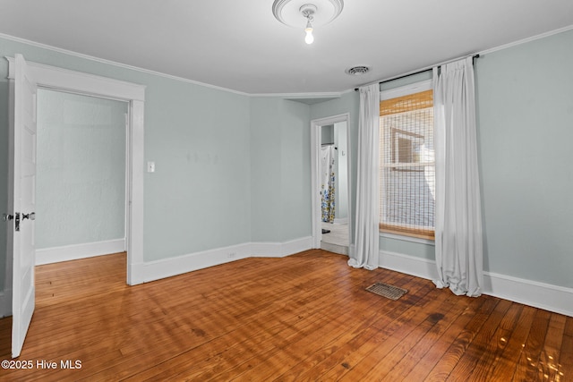 unfurnished room featuring ornamental molding and wood-type flooring