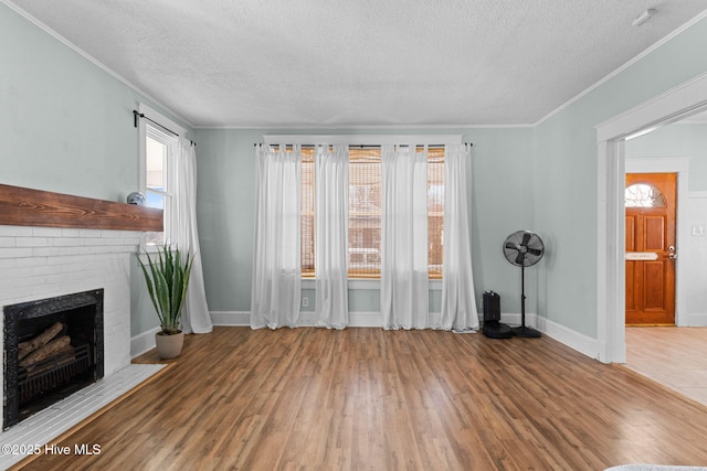 unfurnished living room with a fireplace, hardwood / wood-style floors, and crown molding