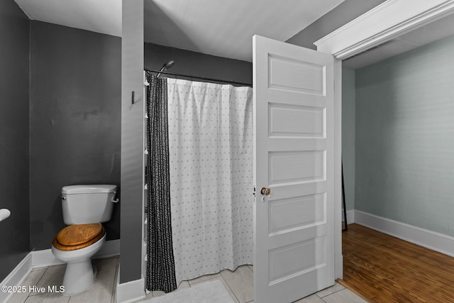 bathroom featuring wood-type flooring, curtained shower, and toilet