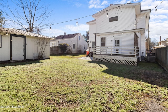 back of property with a storage unit, a wooden deck, and a yard