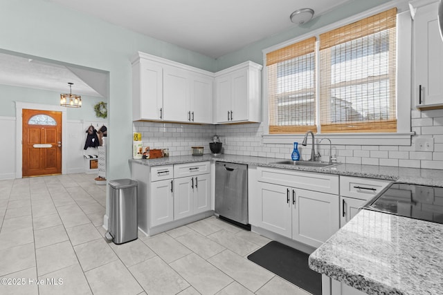 kitchen featuring hanging light fixtures, dishwasher, light tile patterned floors, sink, and white cabinetry